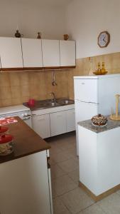 a kitchen with white cabinets and a sink and a counter at Casa Tina in Pomonte +26 photos