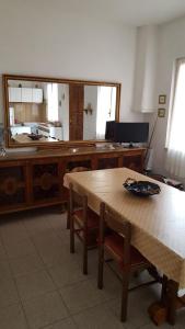 a room with a wooden table and a large mirror at Casa Tina in Pomonte
