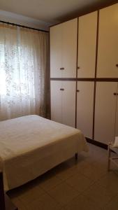 a bedroom with a bed and some white cabinets at Casa Tina in Pomonte