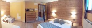 a bedroom with a bed and a wooden wall at Chalet Alpina Hotel & Apartments in La Thuile