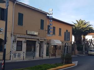 un bâtiment avec un panneau sur le côté d'une rue dans l'établissement Albergo La Portaccia, à Castiglione della Pescaia