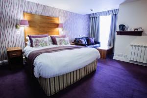 a bedroom with a bed and a dresser at Selkirk Arms Hotel in Kirkcudbright
