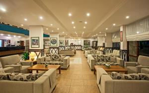 En el vestíbulo hay una sala de estar con sofás y mesas. en Hotel Titan Garden Ultra All Inclusive, en Konaklı