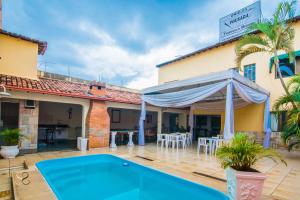 a villa with a swimming pool and a patio at Hotel Pousada Triangulo Mineiro in Uberlândia