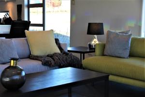 a living room with two couches and a coffee table at Tekapo Sky Lodge in Lake Tekapo