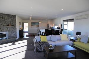 a living room with a couch and a fireplace at Tekapo Sky Lodge in Lake Tekapo