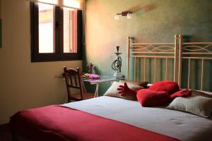 サン・クリストバル・デ・ラ・ラグーナにあるLuxury house in the heart of Tenerifeのベッドルーム1室(赤い枕とテーブル付きのベッド1台付)