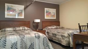 A bed or beds in a room at Historic Hotel Corner Brook