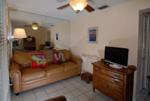 a living room with a couch and a flat screen tv at Seahorse Cottages - Adults Only in Sanibel