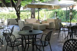 d'une terrasse avec des tables, des chaises et un canapé. dans l'établissement iH Hotels Milano Eur - Trezzano sul Naviglio, à Trezzano sul Naviglio