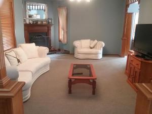 a living room with two white couches and a coffee table at Kiama Guesthouse in Kiama
