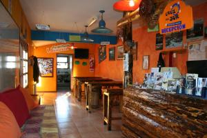 a restaurant with a counter and tables in a room at Hostel Cruz del Sur in Ushuaia