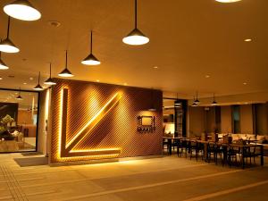 a restaurant with a wall with a lit up sign at hotel androoms Osaka Hommachi in Osaka