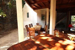 a wooden table and chairs on a patio at Boa Hill Surf House in Nembrala