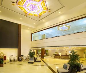 a lobby with a large chandelier in a building at Dimora Hotels And Resorts in Trivandrum