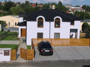 a black car parked in front of a white house at penzion LILIE in Litomyšl