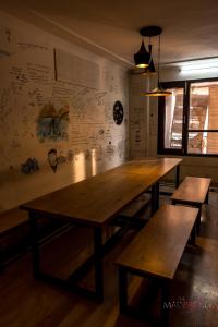 a dark room with a wooden table and a clock on the wall at Madpackers Delhi in New Delhi