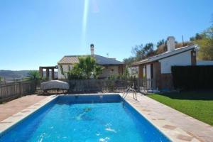 a swimming pool in a yard next to a house at Casa Rural La Herradura in Antequera