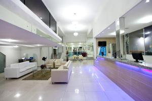 a living room with white furniture and a lobby at JB Hotel in Petrolina