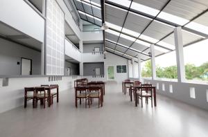 a dining room with wooden tables and chairs at Wisdom Hotel in Samut Songkhram