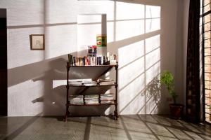 a book shelf with books on it in a room at The Annex, Isai Ambalam guest house in Auroville