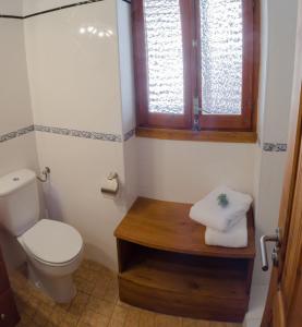 a bathroom with a toilet and a sink and a window at Casa El Cuatro in Beceite +21 photos