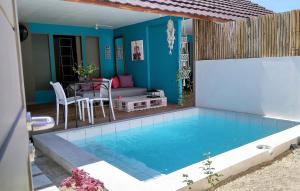 a house with a swimming pool with a table and a couch at Meno Suites in Gili Meno