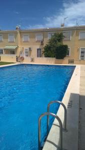 een zwembad met blauw water voor een gebouw bij Casa Los Cerezos in Villamartin