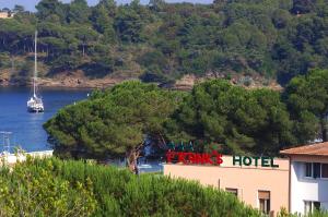 una señal de hotel al lado de un edificio junto a un río en Frank's Hotel, en Capoliveri