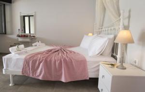 a bedroom with a white bed with a pink blanket on it at Paxos Bay Studios in Gaios
