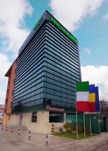 a tall building with a sign in front of it at West Plaza Hotel in Bucharest