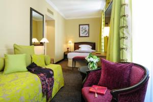 a hotel room with a bed and a couch at Hôtel Tiffany by Fassbind in Geneva