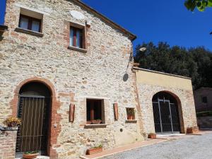 ラポラーノ・テルメにあるAgriturismo Il Solaioの窓と門が二つある古い石造りの建物