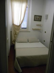 Habitación pequeña con cama y ventana en Mery's House casa vacanza 2, en Fano