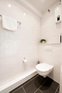 a white bathroom with a toilet and a tub at Appartements am Kleeblatt in Wuppertal