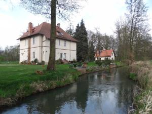 a house with a river in front of it at Pension Bier in Burg