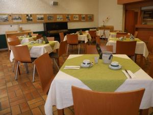 a dining room with tables and chairs with yellow and green table cloth at Hotel Sommerhaus am Internats-Campus in Bad Leonfelden