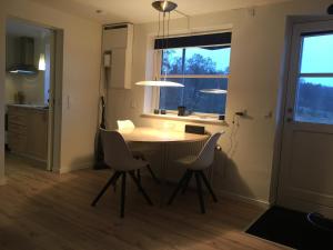 a kitchen with a table and chairs and a window at Julsø lejligheden in Silkeborg