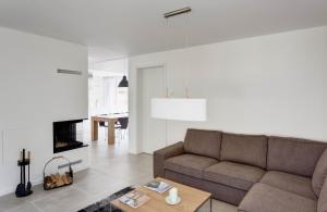 ein Wohnzimmer mit einem Sofa und einem Kamin in der Unterkunft Ferienhaus Lillesol in Breege
