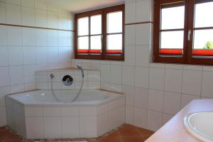 un bagno con vasca e lavandino di Hotel-Gasthof Kramerwirt a Irschenberg