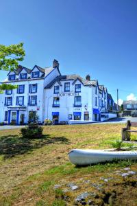 um barco sentado na relva em frente a um edifício em Lion Hotel & Studio Apartments em Criccieth