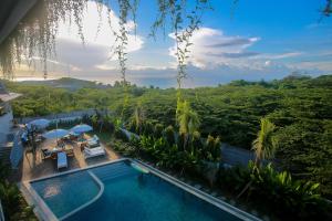 a swimming pool with a view of the jungle at Padang Padang Inn in Uluwatu
