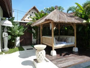 a gazebo with a bed and a thatch roof at La Dolce Villa in Seminyak