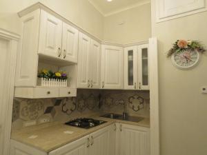 a kitchen with white cabinets and a sink at Le Ninfe Luxury Rooms in Naples