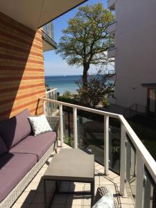 balcón con sofá y vistas al océano en Strandperle 5, en Scharbeutz