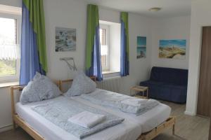 a bedroom with a bed and a blue couch at Apartmenthaus Seestern in Neßmersiel