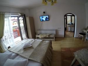 une chambre avec un lit et une télévision au mur dans l'établissement Casa de Vacanta Razvan si Andrei, à Sinaia