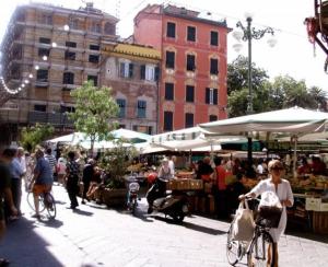 a group of people riding bikes through an outdoor market at Hotel Dell'Orto in Chiavari