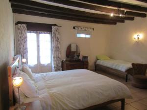 Un dormitorio con una gran cama blanca y una ventana en TheSecretGarden-France, en Courdemanche