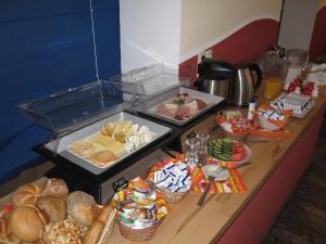 a buffet with bread and other food on a counter at Hotel My Bed Dresden in Dresden